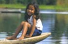 a Manobo girl in a hand-carved canoe